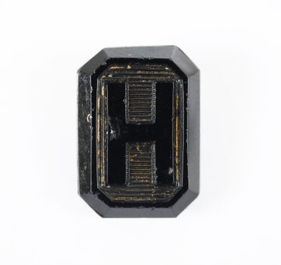 un gros plan d'un petit objet noir sur une surface blanche