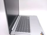 a silver laptop with a black keyboard on a white surface
