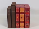trois livres superposés sur une surface blanche