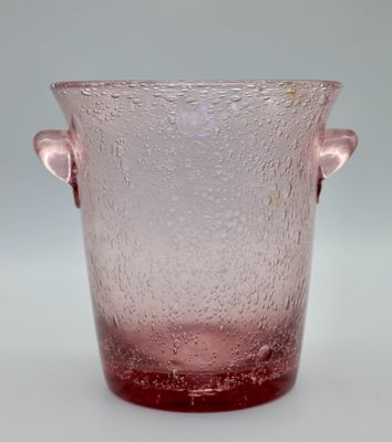vase en verre rose muni de deux anses, posé sur un fond blanc