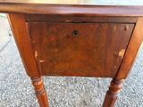 a small wooden table with a drawer on top of it