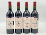 trois bouteilles de vin rouge sont alignées sur une surface blanche