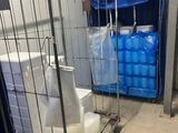 a metal cage with a toilet and a bag of water in it