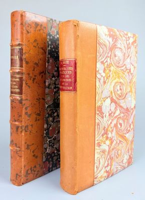 deux vieux livres sont posés côte à côte sur une surface blanche