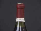 an old bottle of wine sitting on top of a wooden table