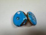 pair of blue and gold decorated boxes sitting on top of a white table