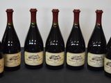 six bouteilles de vin sont alignées sur une table