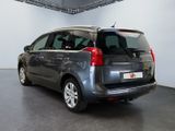 the back of a grey minivan parked inside of a building