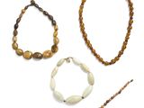 trois bijoux, dont un bracelet en perles, un collier et un bâtonnet orné de perles