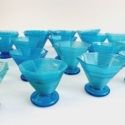 a lot of blue glass cups sitting on a table
