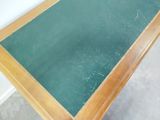 a table with a green glass top and a wooden frame