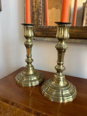 two candles that are sitting on top of a wooden table