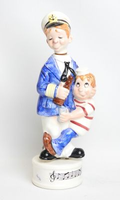 a figurine of a sailor holding a boy