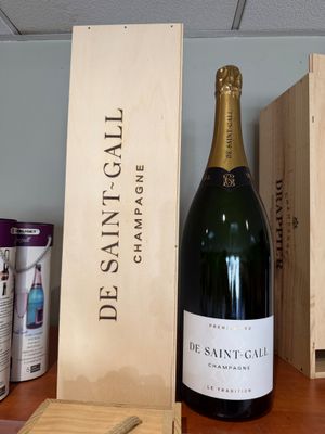 une bouteille de vin posée sur une table à côté d'une caisse en bois