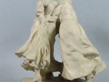 statue of a couple kissing on a rock on a gray background