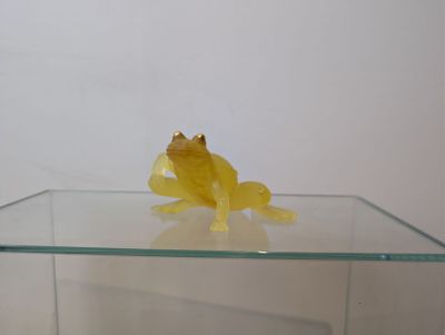 a yellow frog sitting on top of a glass table