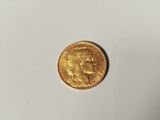 a close up of a gold coin on a white surface