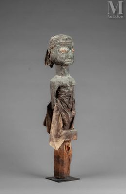 a wooden statue of a woman with a hat on her head