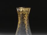 un vase en verre posé sur une table, sur fond noir