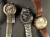 three watches are sitting on a table with a watch on it