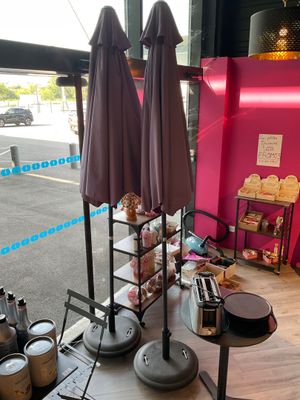 two umbrellas that are on a table in front of a pink wall