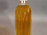 a small bottle of perfume sitting on a white surface