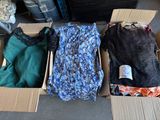 three boxes of clothes are sitting on the floor in a room