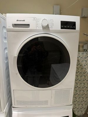 un lave-linge et un sèche-linge blancs placés l'un à côté de l'autre