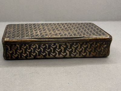 une vieille boîte en métal posée sur une table blanche