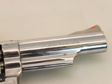 a silver revolver with a red handle on a white surface