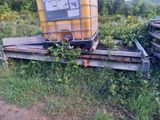a large yellow tank sitting on a trailer in the grass