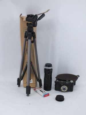 un trépied, un appareil photo et d'autres objets sur fond blanc