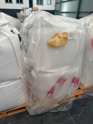une palette remplie de grands sacs contenant une matière blanche
