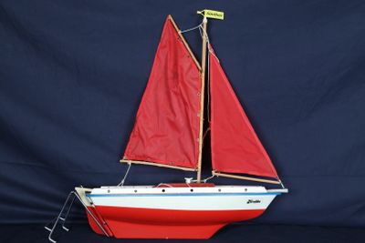 un voilier rouge posé sur une surface noire