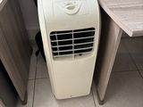 a small air conditioner sitting on the floor next to a desk