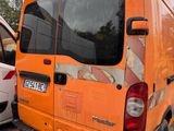 an orange van parked next to a white van in a parking lot