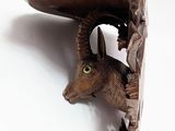 a wooden animal head mounted on a wall