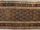 un vieux tapis orné d'un motif marron et noir