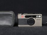 a small camera and a wallet on a black surface