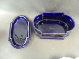 two blue dishes sitting on a table next to each other