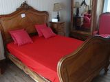 un lit avec des draps et des oreillers rouges dans une chambre