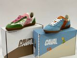 two pairs of shoes are sitting on top of a cardboard box