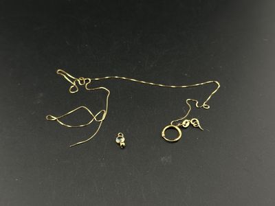 a close up of a pair of gold earrings on a black surface