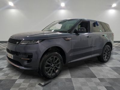 a grey land rover parked in a garage with a checkered floor