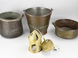 three metal buckets and a metal candle holder on a white surface