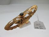 une image représentant un bracelet en or orné d'une pierre noire