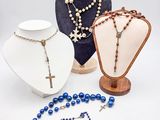 plusieurs colliers et bracelets exposés sur un support blanc