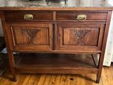 a wooden cabinet with a marble top on a hard wood floor