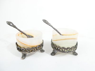 two cups with spoons in them sitting on a table