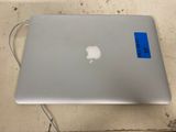 a silver apple laptop with a blue sticker on it